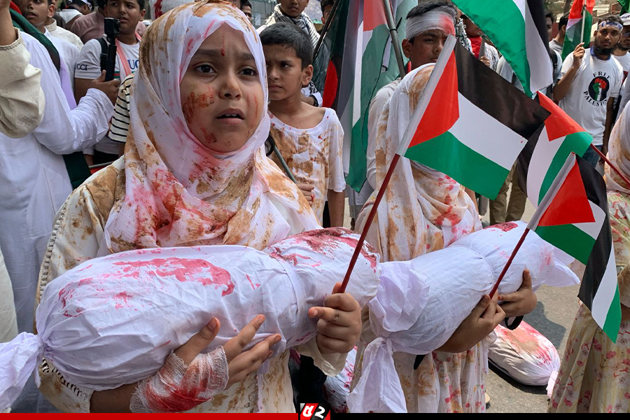 কাফনের কাপড় মোড়ানো প্রতীকী লাশ, মুখে রক্ত ও বেদনার ছাপ, মনে হচ্ছে যেনো গাজার কোনো এক শিশু ঢাকার রাজপথে নেমেছে 